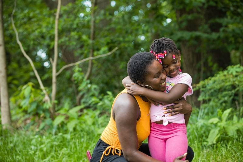 Woman hugging child in nature