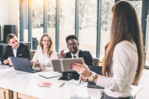 Woman showing off tablet at business meeting