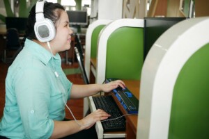 Blind Woman wearing headphones and using a computer