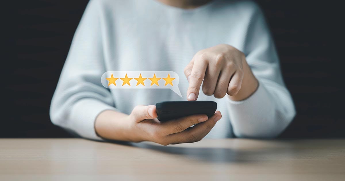 Online-Review Finger typing on phone showing 5 star review in a bubble above